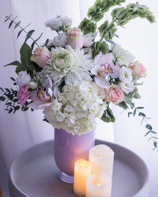 orchids, pink roses, white hydrangea, bells of Ireland, eucalyptus, pink vase, white and pink flower arrangement