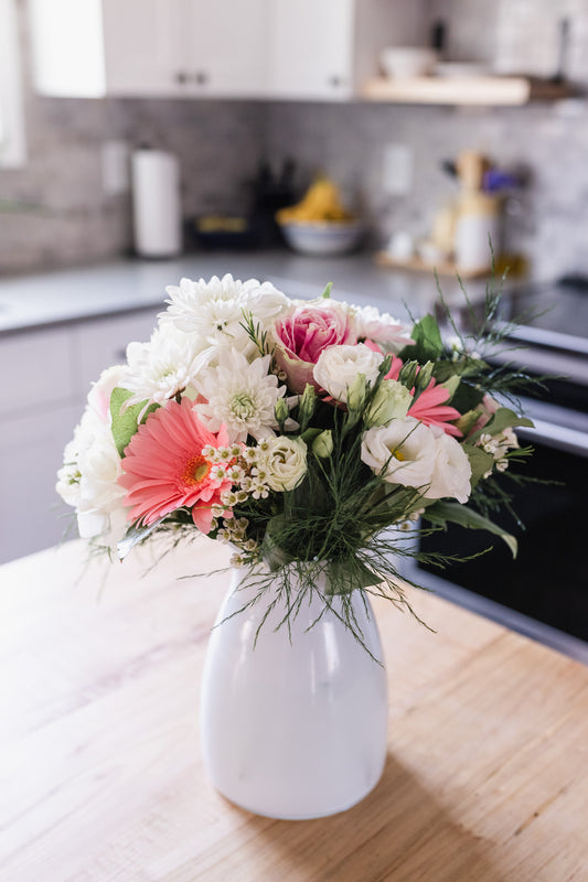 A contemporary white vase containing a beautiful arrangement of pink and white flowers, for the home